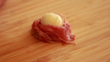 Kadınların elleri Cadılar Bayramı 'nda Prosciutto, Mozzarella ve Yeşil Zeytinli Korku Elleri Yemeği hazırlıyor.