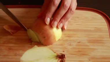 Kadın eli ustalıkla sarı soğan kesiyor.