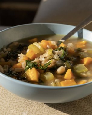 Delicious Italian White Bean Soup in a Blue Bowl  Close-Up clipart