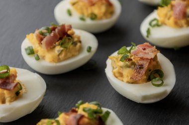 Baharatlı yumurta, kıtır domuz pastırması ve yeşil soğan. Lezzetli ve renkli bir aperatif oluşturuyor. Parti başlatıcıları, toplantılar ya da tatil tabakları için mükemmel.