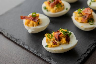  Baharatlı yumurta, kıtır domuz pastırması ve yeşil soğan. Lezzetli ve renkli bir aperatif oluşturuyor. Parti başlatıcıları, toplantılar ya da tatil tabakları için mükemmel.