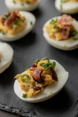  Baharatlı yumurta, kıtır domuz pastırması ve yeşil soğan. Lezzetli ve renkli bir aperatif oluşturuyor. Parti başlatıcıları, toplantılar ya da tatil tabakları için mükemmel.