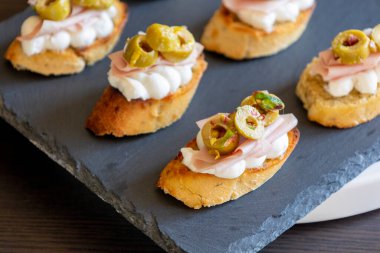 Üstü çırpılmış ricotta ve ince mortadella dilimleriyle kaplanmış İtalyan crostini 'si.