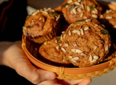 Tohumlarla kaplı taze pişmiş sağlıklı keklerin yakın çekimi. Besleyici atıştırmalıklar, kahvaltı ve sağlıklı ikramlar için mükemmel.