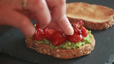 Domatesli avokado tostu ve yakın plan kızarmış domuz pastırması.