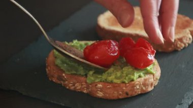 Domatesli avokado tostu ve yakın plan kızarmış domuz pastırması.