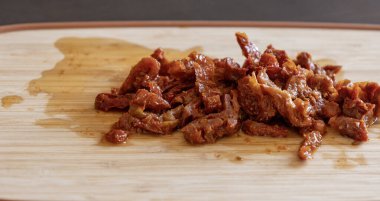 Tahta üzerinde doğranmış güneşte kurutulmuş domatesler. Yakın plan.