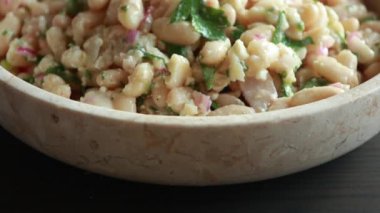 Feta ve Red Onion Close-Up ile bir kasede beyaz fasulye salatası.