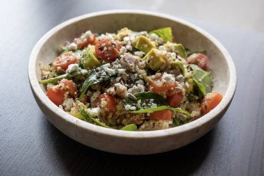 Quinoa, avokado, karışık tohum ve peynirden yapılmış canlı ve besleyici bir salatanın yakın çekimi, sağlıklı bir yemek için protein ve sağlıklı yağlarla paketlenmiş.
