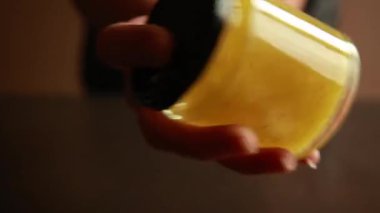 Kavanozda lezzetli bir salata sosu hazırlayan birinin yakın çekimi. Malzemeler taze, ev yapımı bir sos için karıştırılıyor.