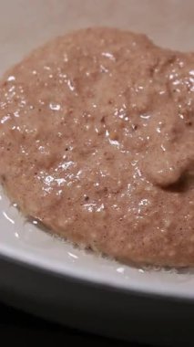 Beyaz bir tavada pişen lezzetli ve sağlıklı muzlu gözlemelerin yakın çekimi.