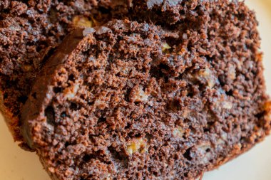 Yeni dilimlenmiş muzlu çikolatalı ekmeğin yakın çekimi, nemli dokusunu gösteriyor, zengin çikolata kıvrımları