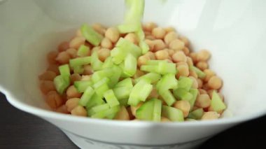 Beyaz kasede nohut, salatalık, kırmızı soğan ve peynirli lezzetli sağlıklı salata.