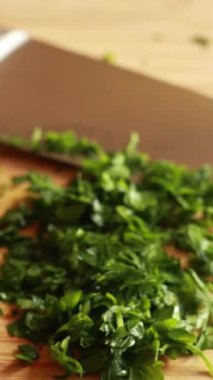 Tahta kesme tahtasının üzerinde maydanoz doğruyorum.