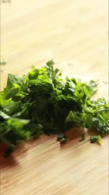 Tahta kesme tahtasının üzerinde maydanoz doğruyorum.