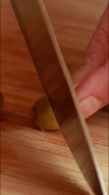  Bir kadının elinin, taze yeşil zeytinleri bıçakla dilimlerken yakın plan çekimi.