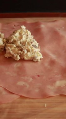 Lezzetli aperatifler yapmak için krem peynirle doldurulmuş mortadella salamı.