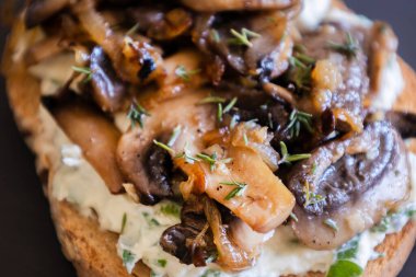 Siyah taşlı tabakta krem peynirli, mantarlı ve karamelli soğanlı nefis mantarlı tost.