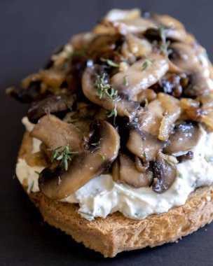 Siyah taşlı tabakta krem peynirli, mantarlı ve karamelli soğanlı nefis mantarlı tost.