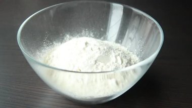 Büyük beyaz bir kasede lezzetli mısır börekleri yapmak için hamuru karıştırıyorum.