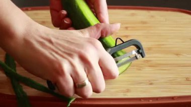 Kadın elleri yakın plan salatalık soyarken