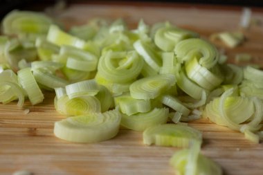  Tahta kesme tahtasında taze pırasa dilimlenmiş.