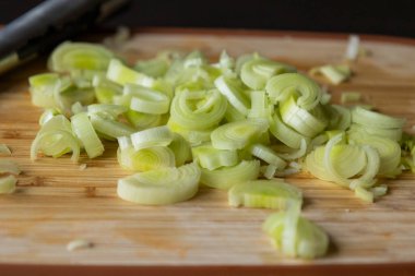 Tahta kesme tahtasında taze pırasa dilimlenmiş.