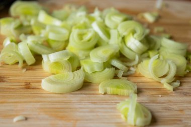  Tahta kesme tahtasında taze pırasa dilimlenmiş.