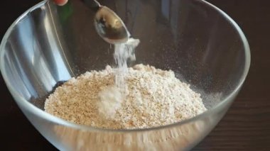 Kuru malzemeyi yakın plan bir kasede pişirmek için karıştırıyorum.