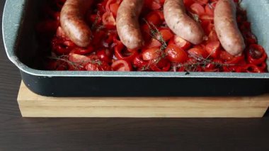  Sosis, kırmızı dolma biber, soğan ve domateslerin birlikte pişirildiği lezzetli bir akşam yemeği.