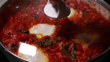 Shakshuka domatesi ve yumurta pişiriyorum. Kahvaltıyı fırının üstünde yakın plan bir tavada yapıyorum.