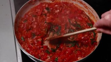 Shakshuka domatesi ve yumurta pişiriyorum. Kahvaltıyı fırının üstünde yakın plan bir tavada yapıyorum.