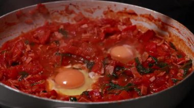 Shakshuka domatesi ve yumurta pişiriyorum. Kahvaltıyı fırının üstünde yakın plan bir tavada yapıyorum.