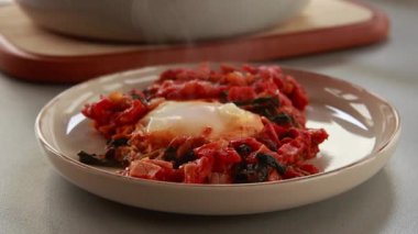 Shakshuka kavrulmuş kırmızı dolma biber, yumurta ve ıspanak yakın planda servis edilir.