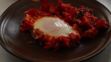 Shakshuka kavrulmuş kırmızı dolma biber, yumurta ve ıspanak yakın planda servis edilir.