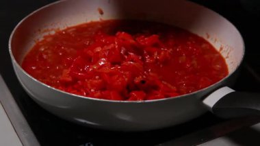 Domates sosuna kavrulmuş kırmızı dolmalık biber ve jambon eklersen tavada pişirirsin.