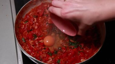 Shakshuka domatesi ve yumurta pişiriyorum. Kahvaltıyı fırının üstünde yakın plan bir tavada yapıyorum.