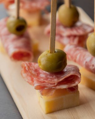  Parmesan peyniri, salam dilimleri ve yeşil zeytinle yapılan mezeler.