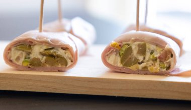 İçinde peynir, mortadella, salam ve yeşil zeytin dilimleri bulunan mezeler.