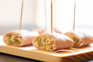 İçinde peynir, mortadella, salam ve yeşil zeytin dilimleri bulunan mezeler.