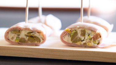 İçinde peynir, mortadella, salam ve yeşil zeytin dilimleri bulunan mezeler.