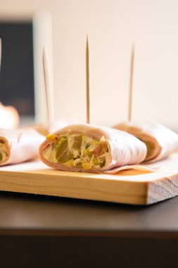 İçinde peynir, mortadella, salam ve yeşil zeytin dilimleri bulunan mezeler.