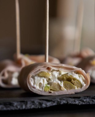 İçinde peynir, mortadella, salam ve yeşil zeytin dilimleri bulunan mezeler.