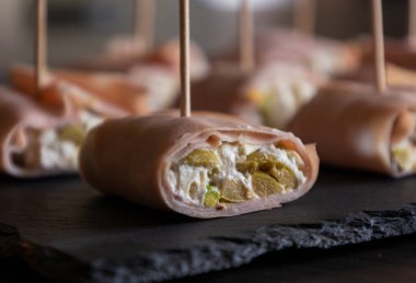 İçinde peynir, mortadella, salam ve yeşil zeytin dilimleri bulunan mezeler.