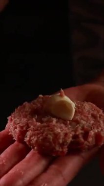 Kadın elleri mozarella ile doldurulmuş köfte yapıyor ve pastırmaya sarılmış, dikey yakın plan.