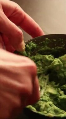 Kadın elleri avokado püresi, tavuk püresi ve salsa sosuyla sağlıklı yemek hazırlıyor.