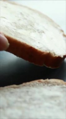 Kadın elleri fırında sandviçleri dikey olarak hazırlıyor.