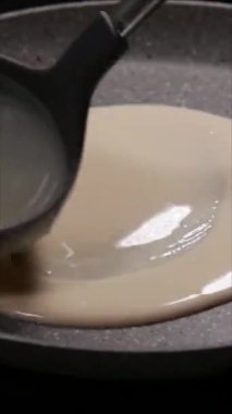 Dikey yakın çekim videosu kremalı bitkisel peynir ve tütsülenmiş somon dilimleriyle dolu ince krepler hazırlama sürecini gösteriyor