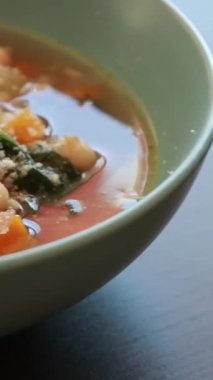  İtalyan fasulyesi ve ıspanak çorbası taze rendelenmiş parmesan peyniri ile nazikçe kaynıyor.