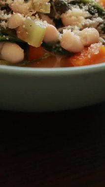  İtalyan fasulyesi ve ıspanak çorbası taze rendelenmiş parmesan peyniri ile nazikçe kaynıyor.